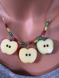 (1461)  Apple Slices Necklace and Earrings  Apples are just over 1" and made with resin.  Earrings come in red, yellow and green, and are on stainless steel ear wires. Necklace has one of each color, and is adjustable from approximately 18 1/2" to 20 1/2". Fun Nickel Free Resin Jewelry, Fun Yellow Nickel-free Jewelry, Fun Red Round Jewelry, Fun Nickel-free Resin Jewelry, Fun Red Resin Jewelry, Nickel-free Fun Resin Jewelry, Apple Necklace, Novelty Resin Dangle Jewelry, Novelty Red Resin Jewelry