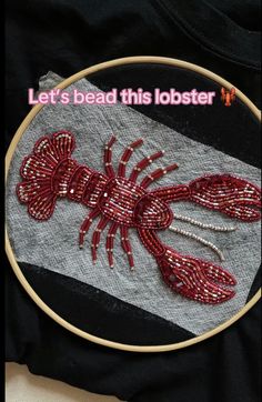 a red lobster embroidered on top of a black t - shirt with the words let's bead this lobster