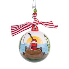 a glass ornament with a santa hat on it's head and fishing rod