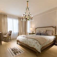 a bedroom with a chandelier hanging from the ceiling and a bed in front of a window