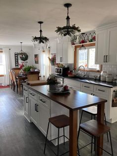 a kitchen filled with lots of white cabinets and counter top next to a dining room table