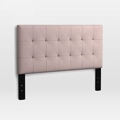 an upholstered headboard with black legs and buttons on the top, against a white background