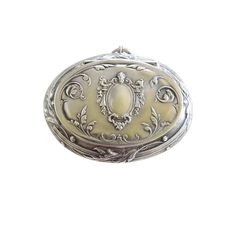 an ornate silver pocket watch on a white background