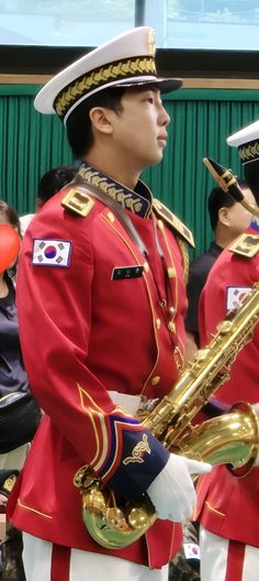 two men in red uniforms are playing instruments