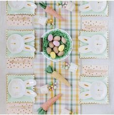 an easter table setting with bunny ears, eggs and candy