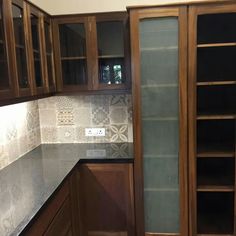 a kitchen with wooden cabinets and marble counter tops