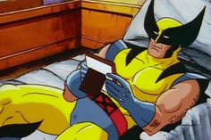 a cartoon character laying in bed reading a book with wolverine on his chest and head turned to the side