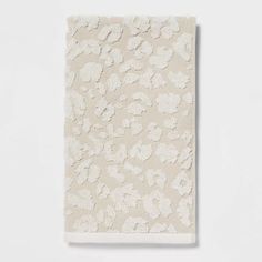 a white towel with floral design on the front and back, in an off - white background