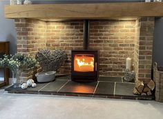 a fire place in the middle of a room with brick walls and stone flooring