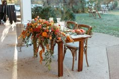 the table is set with flowers and candles for an outdoor dinner party or wedding reception