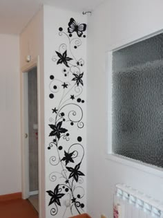 the wall is decorated with black and white flowers, butterflies, and stars on it