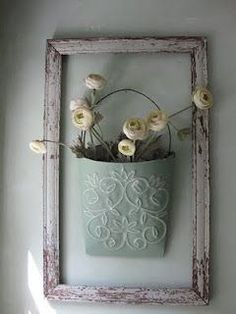 a white frame with flowers in it hanging on the wall