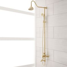 a shower head and hand shower in a bathroom with white tiles on the wall behind it