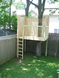 there is a tree house with a ladder to the top and a deck above it