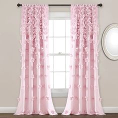 pink curtains with flowers on them in front of a window