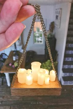 a person holding a small wooden box with candles in it and some lights on the inside