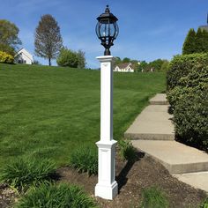 a lamp post in the middle of a grassy area with steps leading up to it