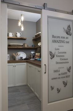 an open door leading into a kitchen with white cupboards and appliances on the wall