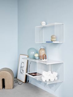 a white shelf with some vases on it and a dog bed in the corner