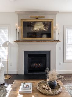 a living room filled with furniture and a fire place in front of a painting on the wall