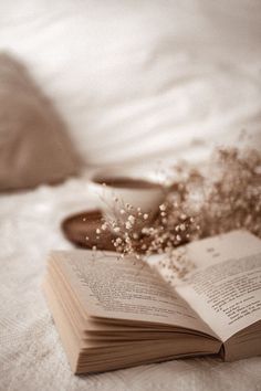 an open book sitting on top of a bed