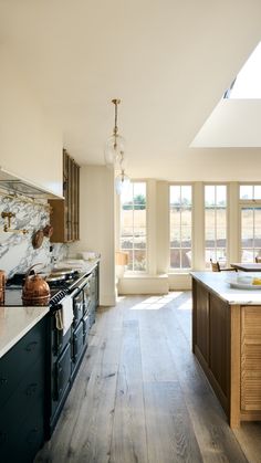 a large kitchen with wooden floors and white walls