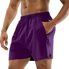 a man with his shirt open wearing purple shorts