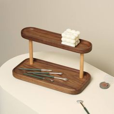 there is a wooden stand with some paint brushes on it and other items next to it