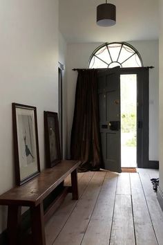 a hallway with a bench and pictures on the wall