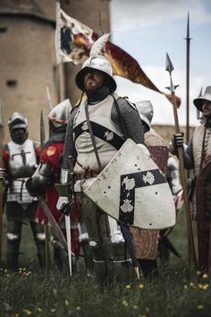 a group of men in armor standing next to each other on top of a field