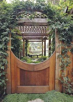 a wooden gate is surrounded by greenery