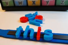 the letters sit on top of each other in front of some sort of magnets