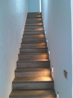 a set of wooden stairs leading up to an open door with light coming from it