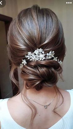 the back of a woman's head wearing a hair comb with flowers on it