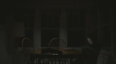 a person sitting at a table in the dark