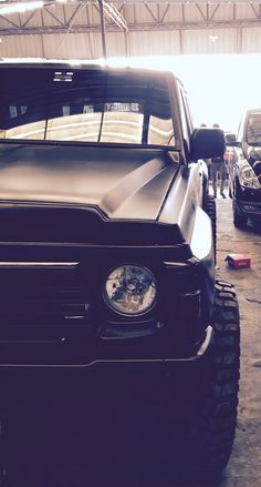 the front end of a black truck parked in a garage