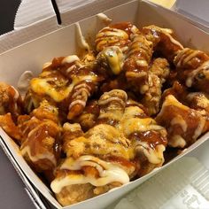 a box filled with meat covered in sauce and cheese