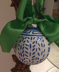 a blue and white ornament with a green bow hanging from it's side