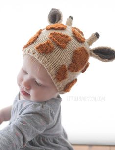 a baby wearing a knitted giraffe hat