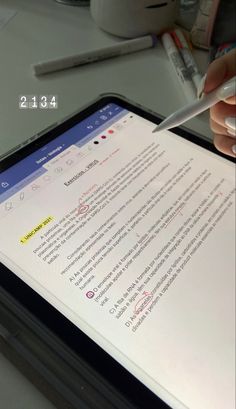 a person is holding a pen and writing on a tablet screen with the text below it