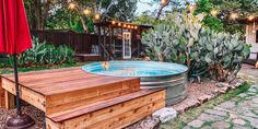 an outdoor hot tub in the middle of a garden