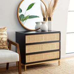 a black and gold dresser with a round mirror on top