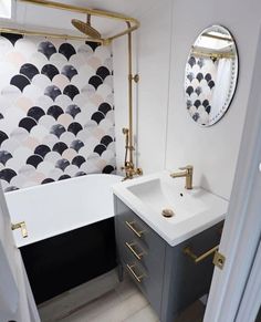 a white sink sitting under a bathroom mirror next to a bath tub and shower head