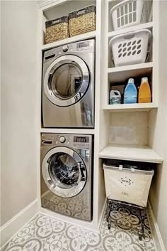 a washer and dryer in a small room with shelves on the wall above them