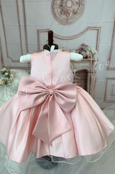 For a vision of chic elegance, look no further than our Glamorous Satin Dress for Little Girls. Available in either a regal white or stunning pink color, this high-quality, one-of-a-kind satin dress is perfect for any formal event or special occasion. The silhouette is classic, with a fitted bodice and a fluffy skirt that swirls delightfully at every twirl. Delicate patterns are beautifully embroidered on the bodice, giving an additional touch of sophistication. Each and every satin dress is met Sleeveless Dresses With Satin Bow For Dress-up, Elegant Sleeveless Dresses For Pageants, Fitted Baptism Dress With Bow, Sleeveless Party Dress With Pink Bow, Elegant Ruffled Baptism Dress For Party, Pink Bow Dress For Dress-up, Princess Style Satin Dress For Party, Princess Style Satin Party Dress, Elegant Spring Baptism Party Dress