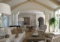 a living room filled with furniture and a chandelier hanging over the top of it