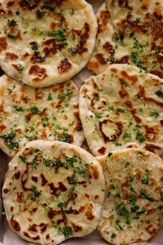 several flat breads with herbs on them in a box