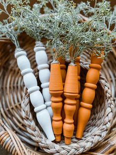 three small carrots are in a wicker basket next to some herbs and pepper shakers