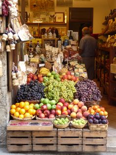 the fruit stand is full of many different types of fruits, including oranges and grapes