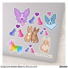 a laptop with many different stickers on the screen and in front of it is an image of dogs